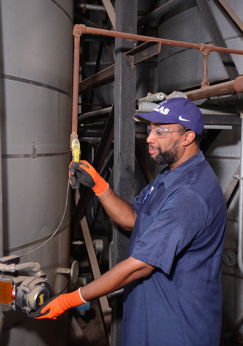 employee working beside tank